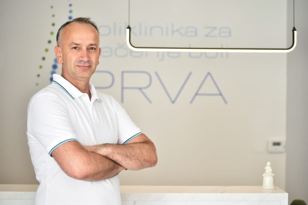 Prim. dr. sc. Oliver Pavlović ispred logotipa Poliklinike Prva